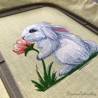 Cute bunny machine embroidery design sniffing a flower, soft spring animal embroidery pattern for kids and creative projects