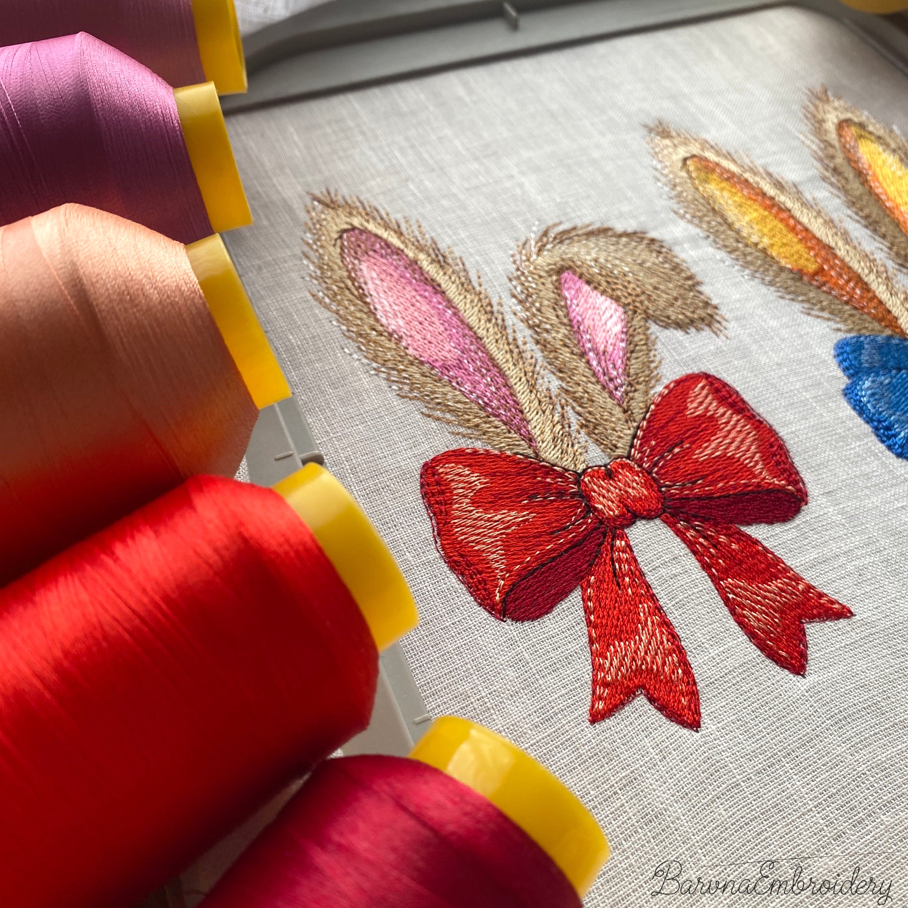 Machine embroidery design of bunny ears with red bow, fluffy fur texture, detailed stitches, embroidery design on dark background.