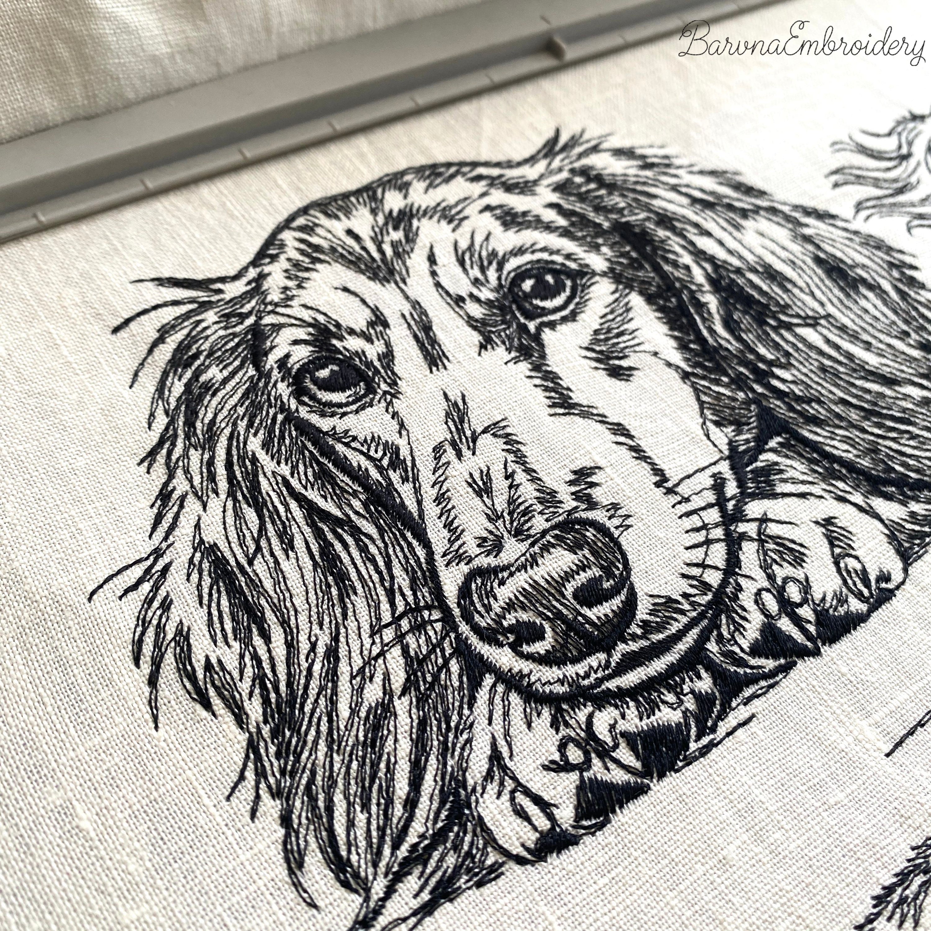 Black and white embroidered illustration of a long-haired dachshund dog. The dog is lying down, with its paws and head resting on a surface. The dog's eyes are open, and it has long, flowing fur.