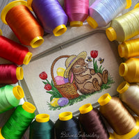 Sleeping Easter bunny machine embroidery design with basket of eggs and spring flowers