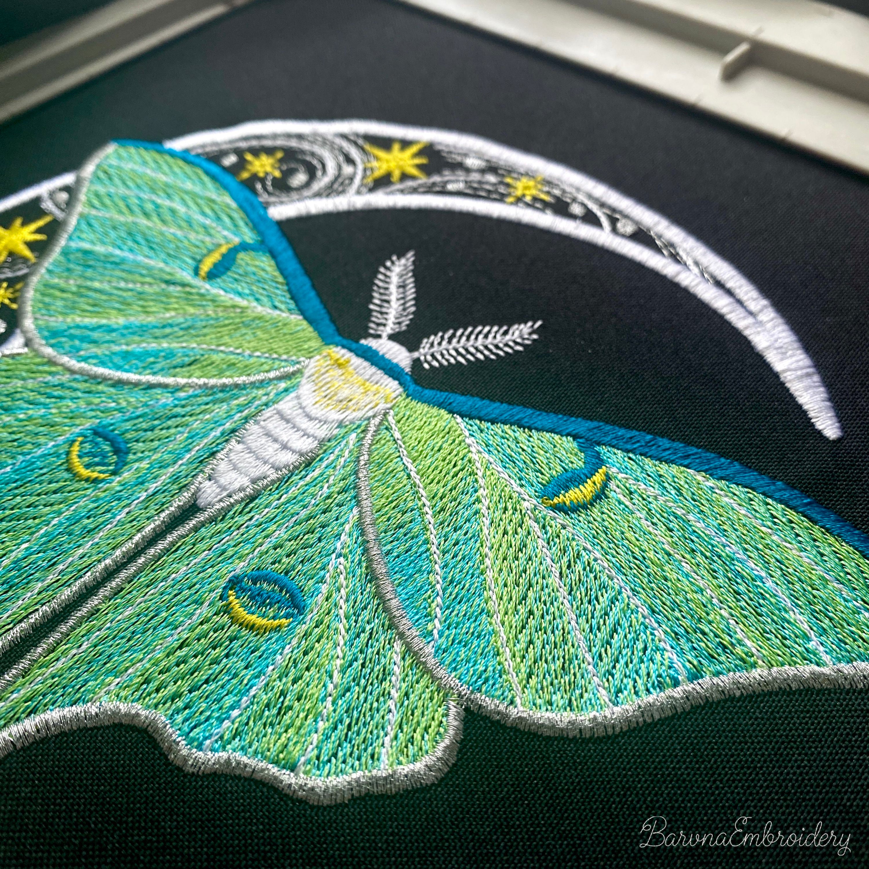 Green luna moth machine embroidery design with crescent moon and stars on dark background