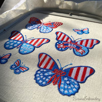 Patriotic butterfly machine embroidery design with decorative stars and number detail.