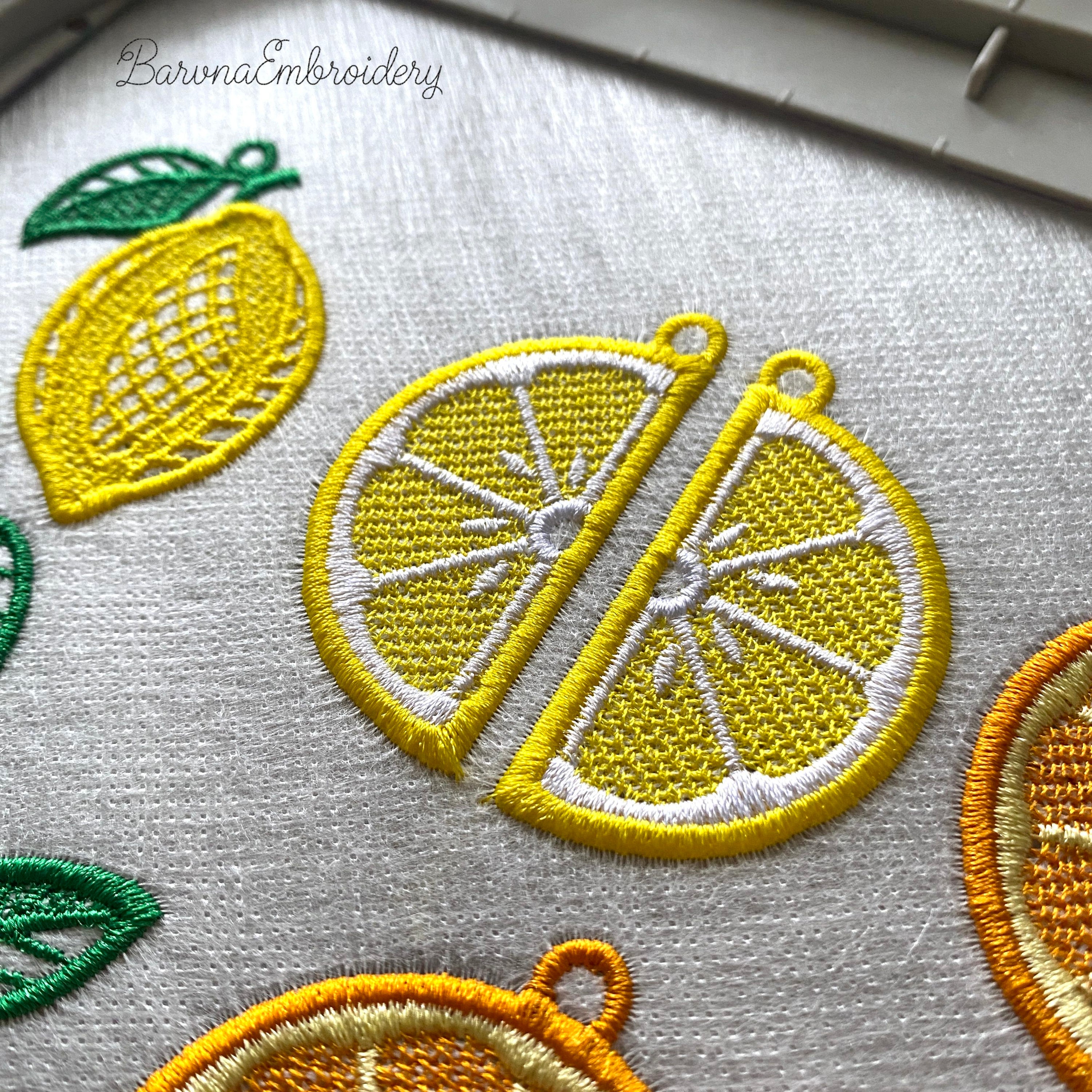 Three pairs of FSL lemon embroidery earrings — half-slice, whole lemon with green leaves, and round citrus slice — displayed on cream fabric, Free Standing Lace machine embroidery design.
