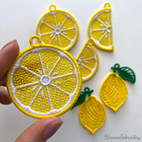 Three pairs of FSL lemon embroidery earrings — half-slice, whole lemon with green leaves, and round citrus slice — displayed on cream fabric, Free Standing Lace machine embroidery design.
