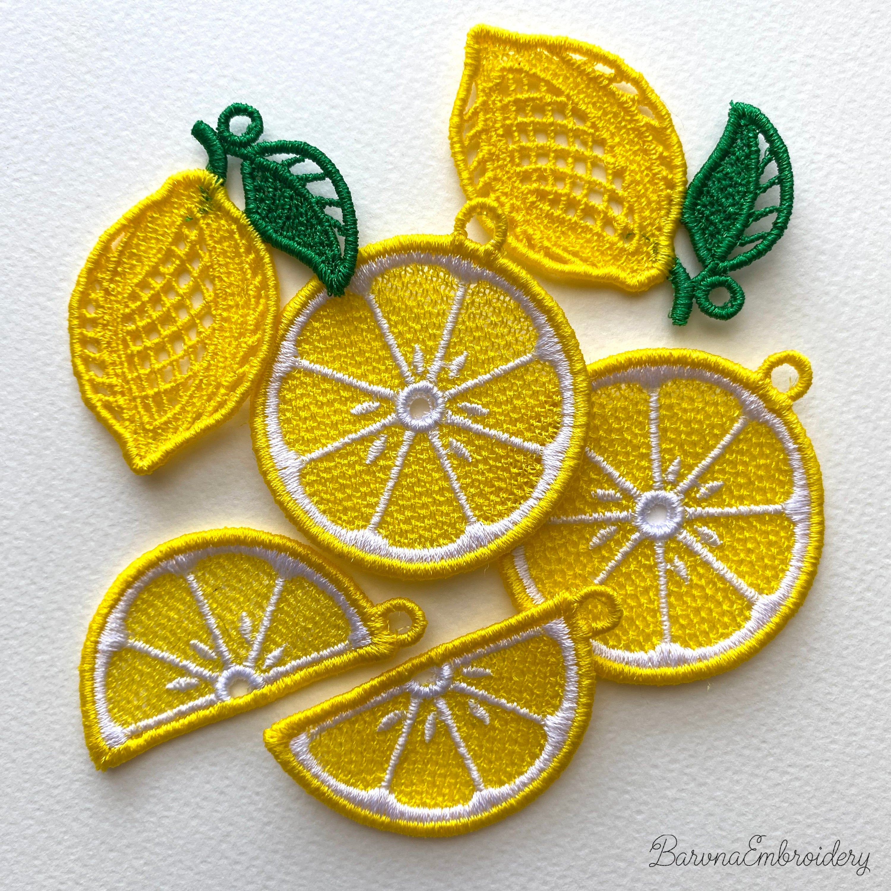 Three pairs of FSL lemon embroidery earrings — half-slice, whole lemon with green leaves, and round citrus slice — displayed on cream fabric, Free Standing Lace machine embroidery design.