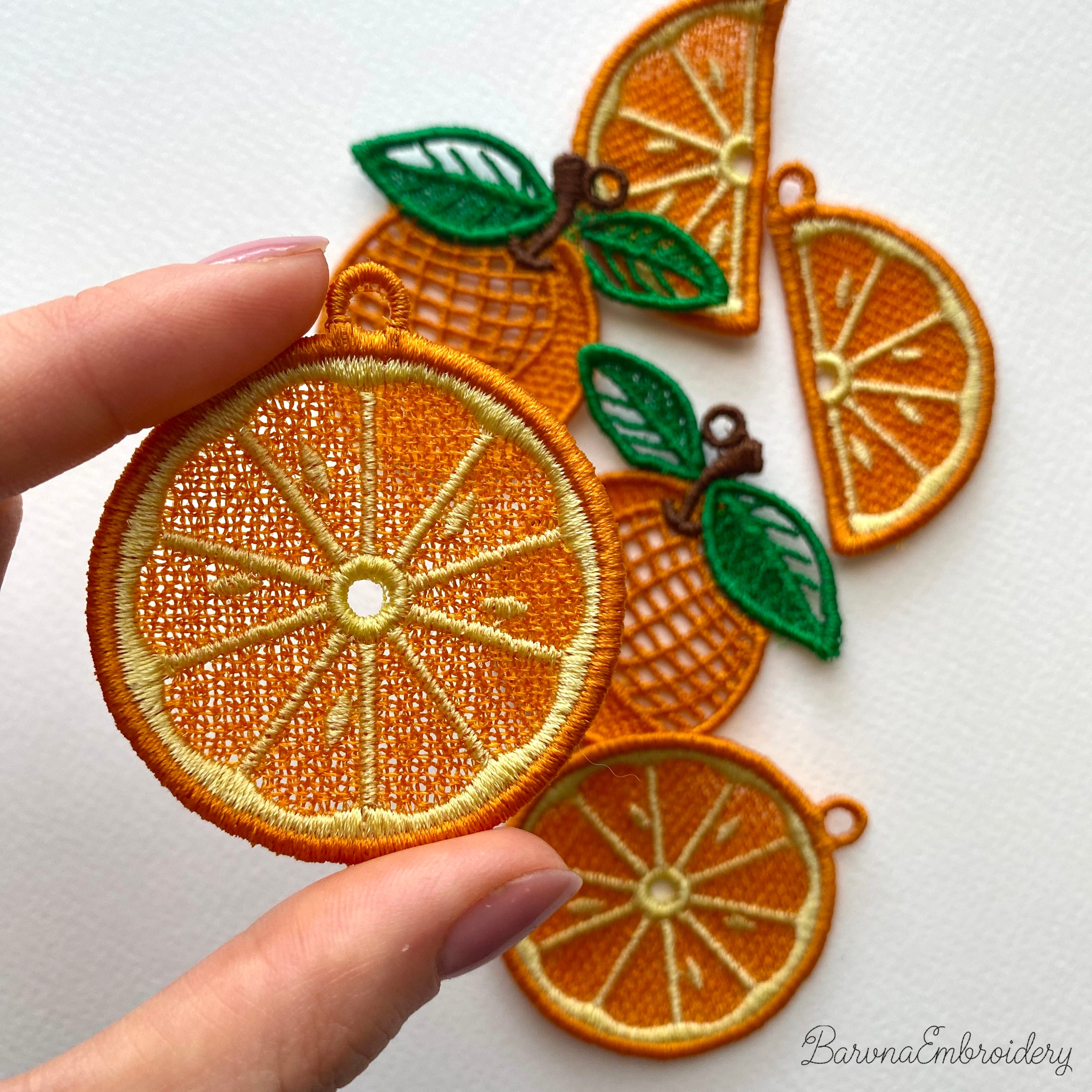 Three pairs of FSL orange embroidery designs — half-slice, whole orange with green leaves, and round citrus cross-section — Free Standing Lace machine embroidery pattern for earrings and pendants.