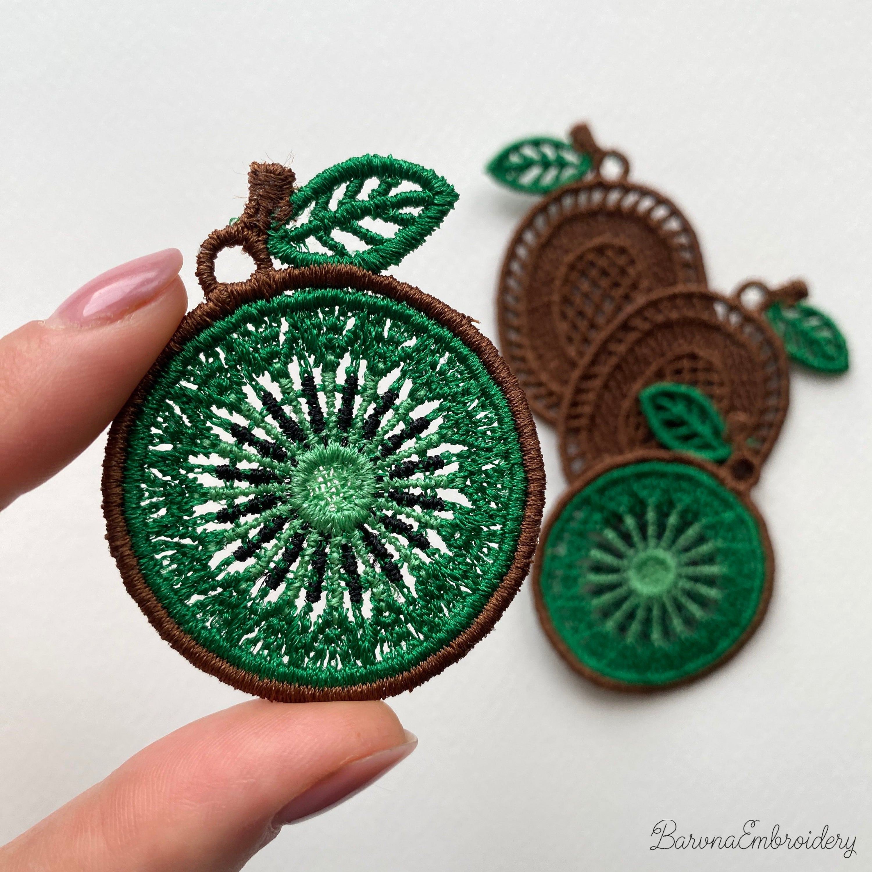 Four FSL kiwi embroidery designs in two styles — green kiwi cross-section and brown whole kiwi fruit — shown as mirrored pairs, Free Standing Lace machine embroidery pattern for earrings and pendants.