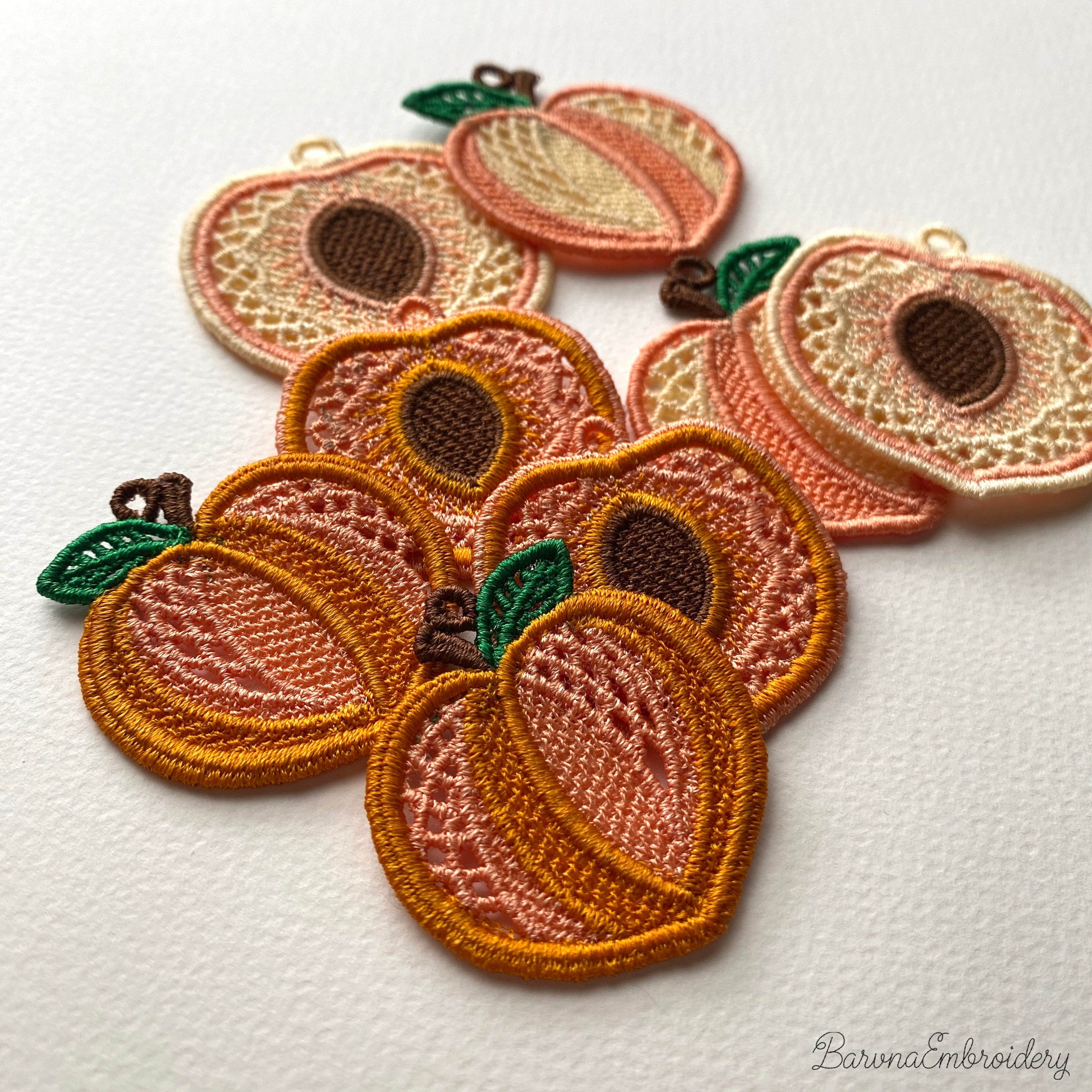 FSL peach embroidery designs in two styles — symmetrical peach half with stone center and whole peach with green leaf — shown as mirrored pairs, Free Standing Lace machine embroidery pattern for earrings and pendants.
