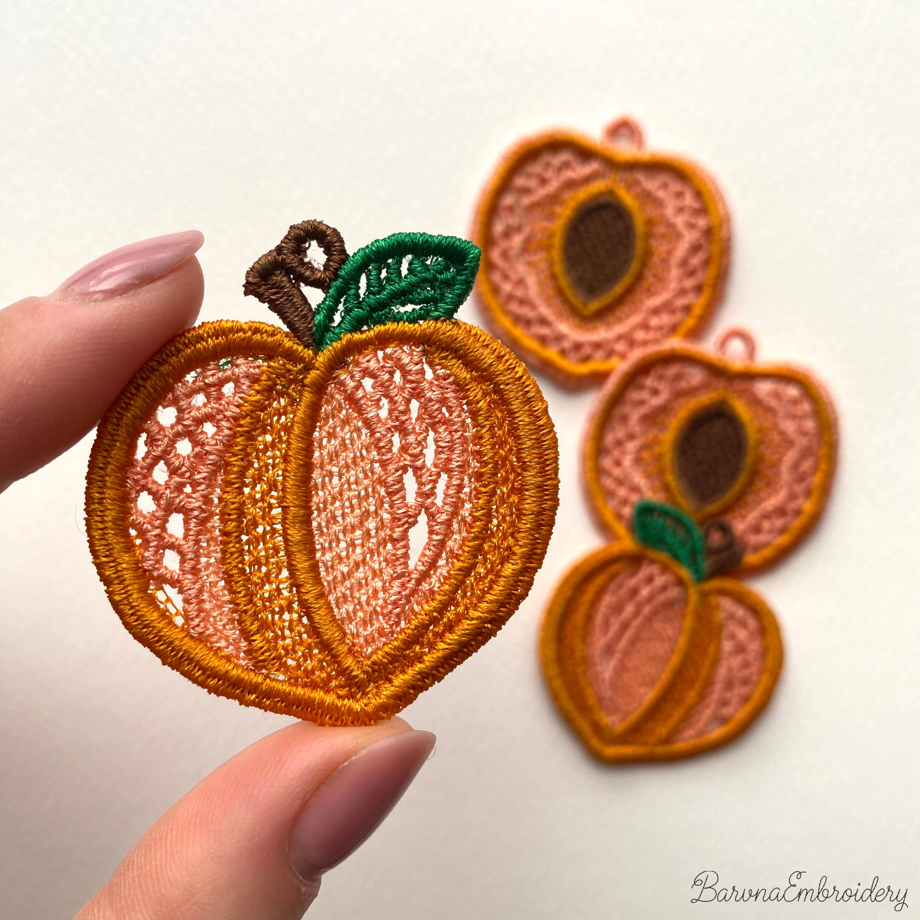 FSL peach embroidery designs in two styles — symmetrical peach half with stone center and whole peach with green leaf — shown as mirrored pairs, Free Standing Lace machine embroidery pattern for earrings and pendants.