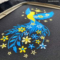 Blue and yellow flying bird embroidery design with stars and flowers trailing from wings – symbolic Ukrainian patriotic motif.