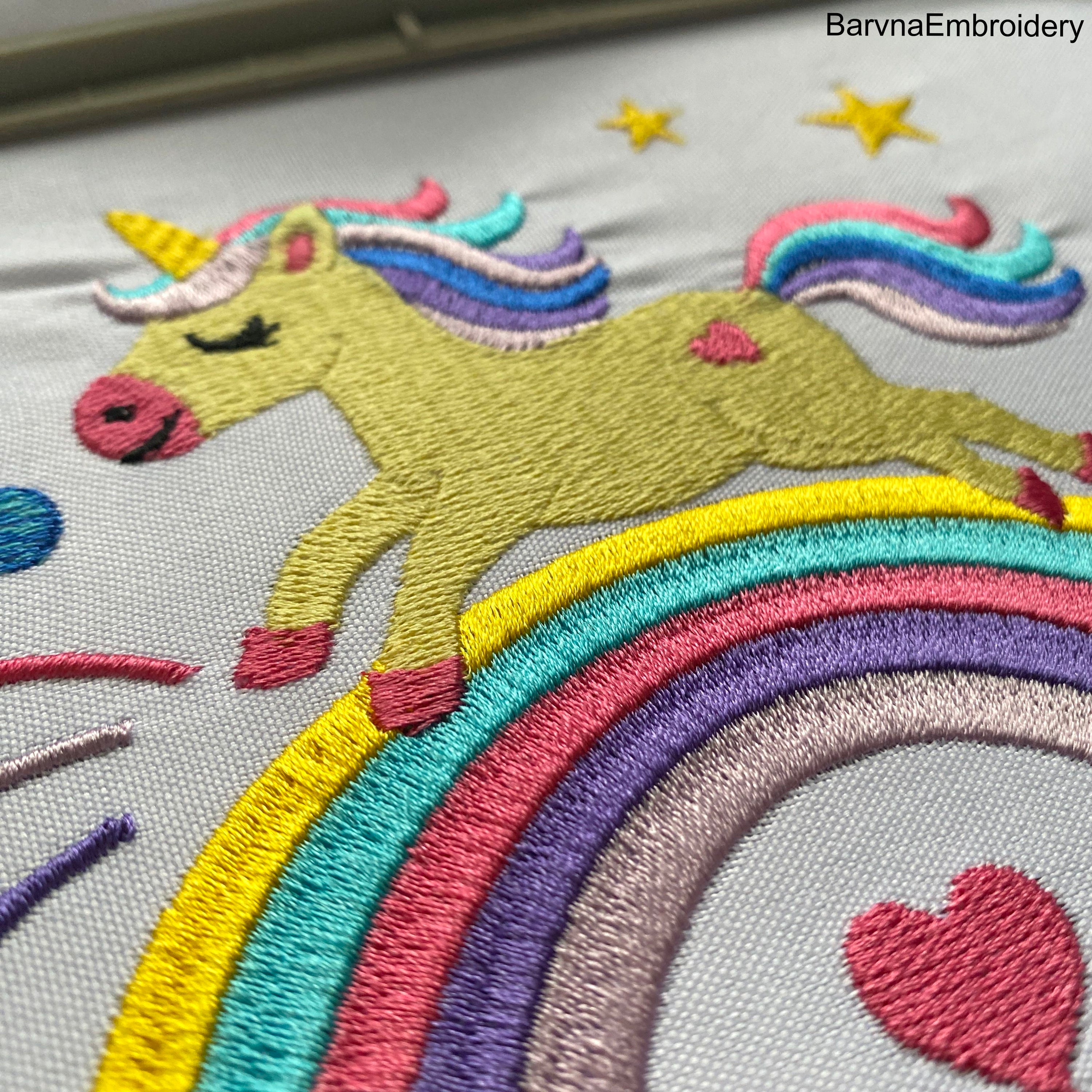 Cute unicorn embroidery design running on a rainbow with stars and clouds – ideal for girls’ clothes or nursery decor.