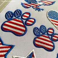 Machine embroidery design of a paw with the American flag inside, great for patriotic pet lovers.