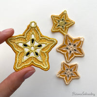 FSL carambola star fruit embroidery designs in two sizes — warm gold lace star shape with cream inner pattern and dark seed details — finished stitched results, Free Standing Lace machine embroidery pattern for earrings and pendants.