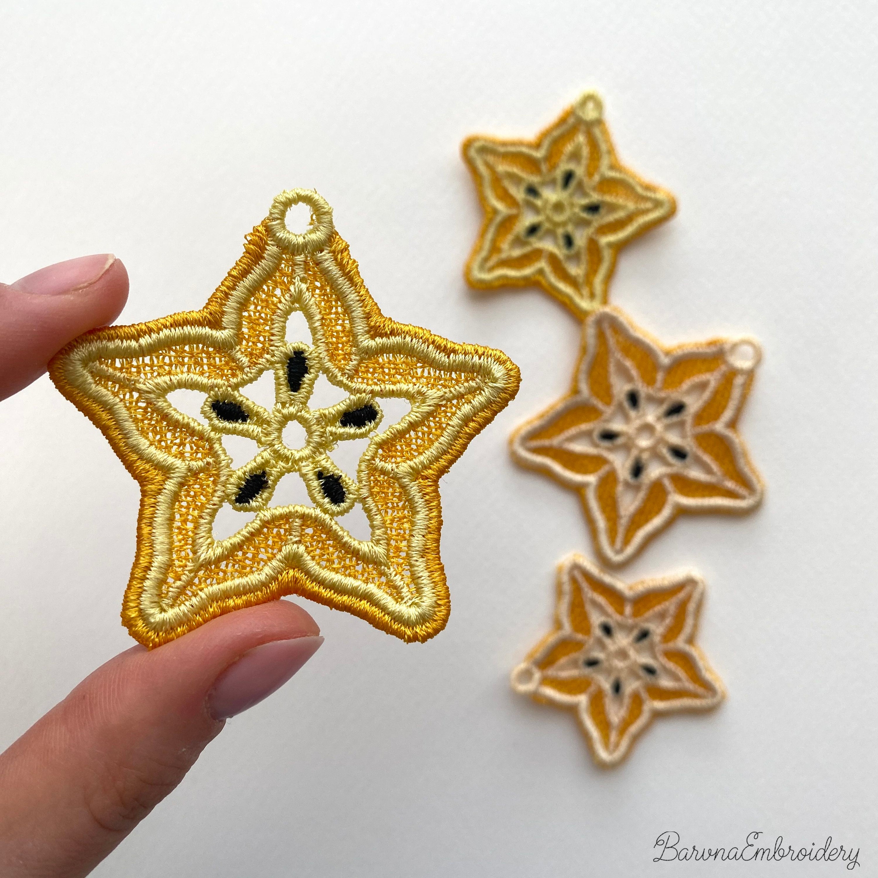 FSL carambola star fruit embroidery designs in two sizes — warm gold lace star shape with cream inner pattern and dark seed details — finished stitched results, Free Standing Lace machine embroidery pattern for earrings and pendants.