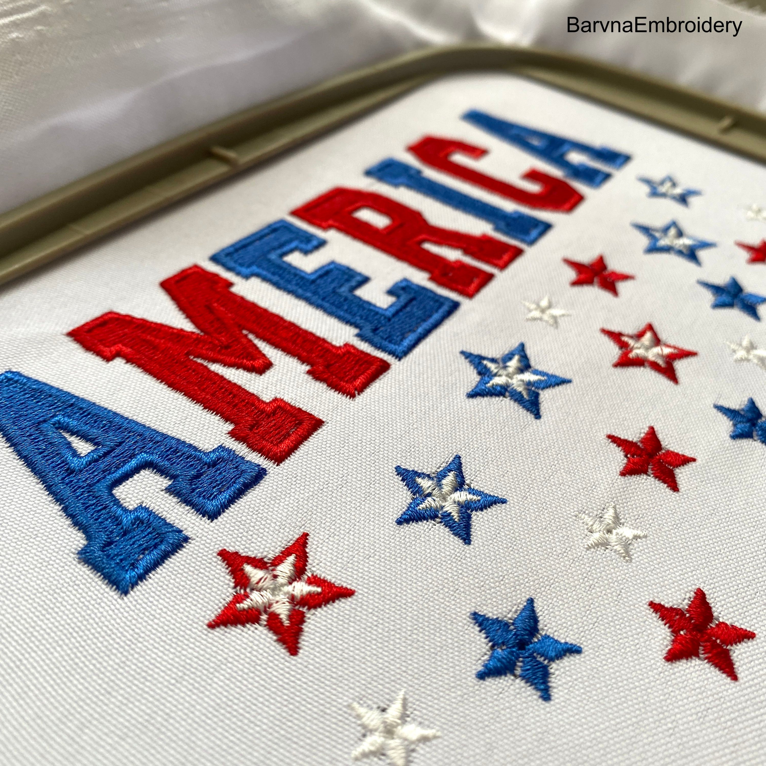 Machine embroidery design featuring the word “America” in bold red and blue letters with scattered red, white, and blue stars below, perfect for patriotic projects.