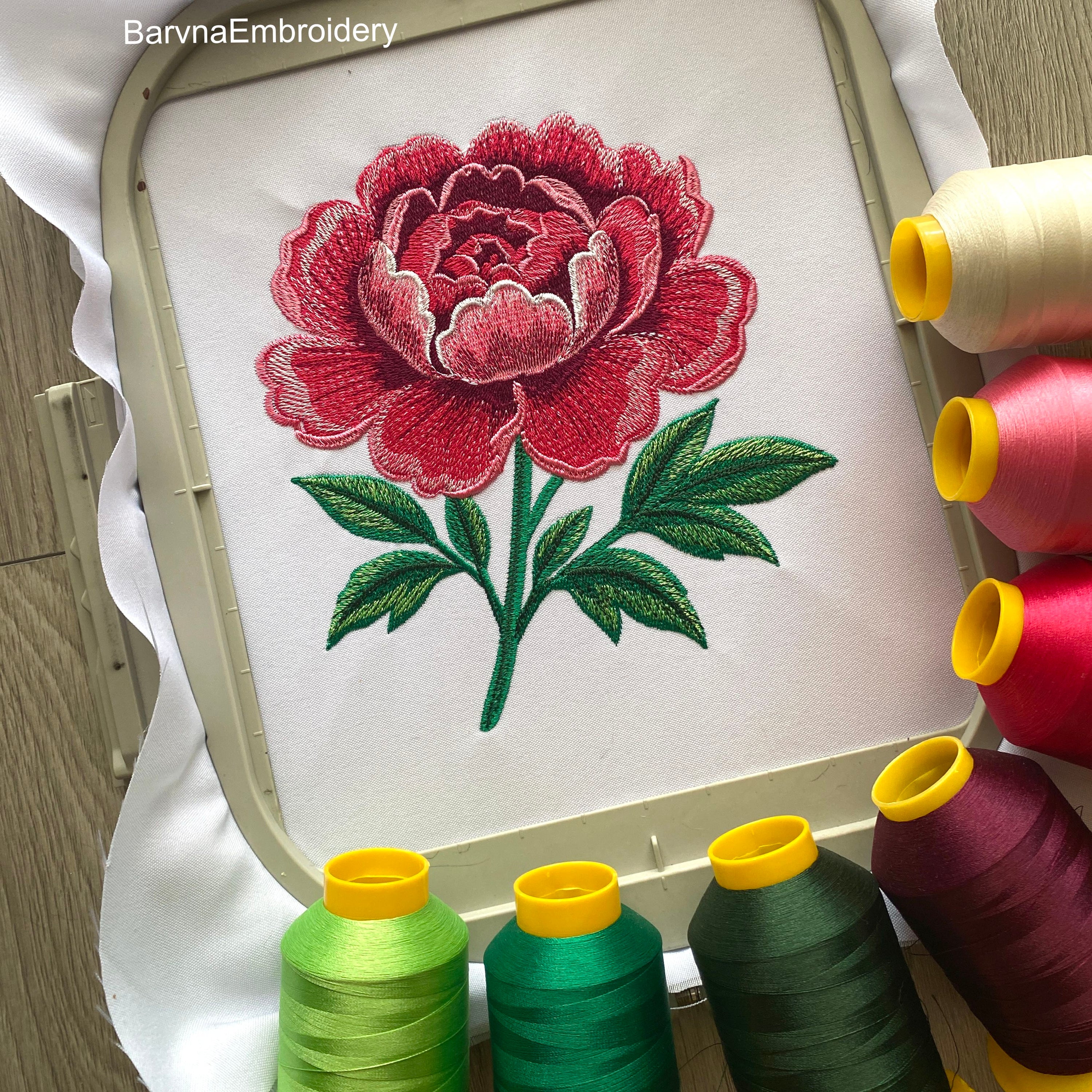 Machine embroidery design of a large pink peony flower with detailed stitching and green leaves, perfect for floral-themed projects and elegant decor.