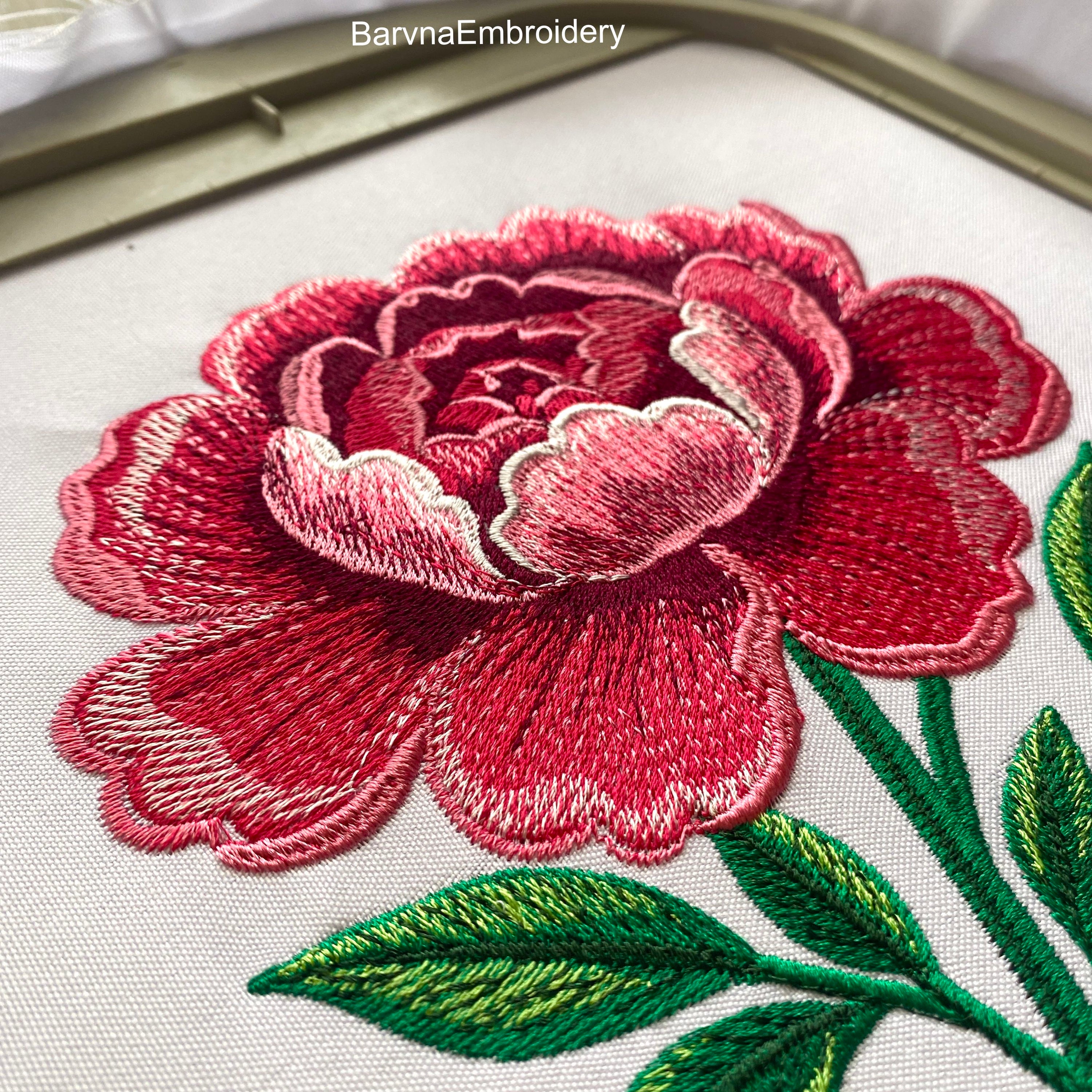 Machine embroidery design of a large pink peony flower with detailed stitching and green leaves, perfect for floral-themed projects and elegant decor.
