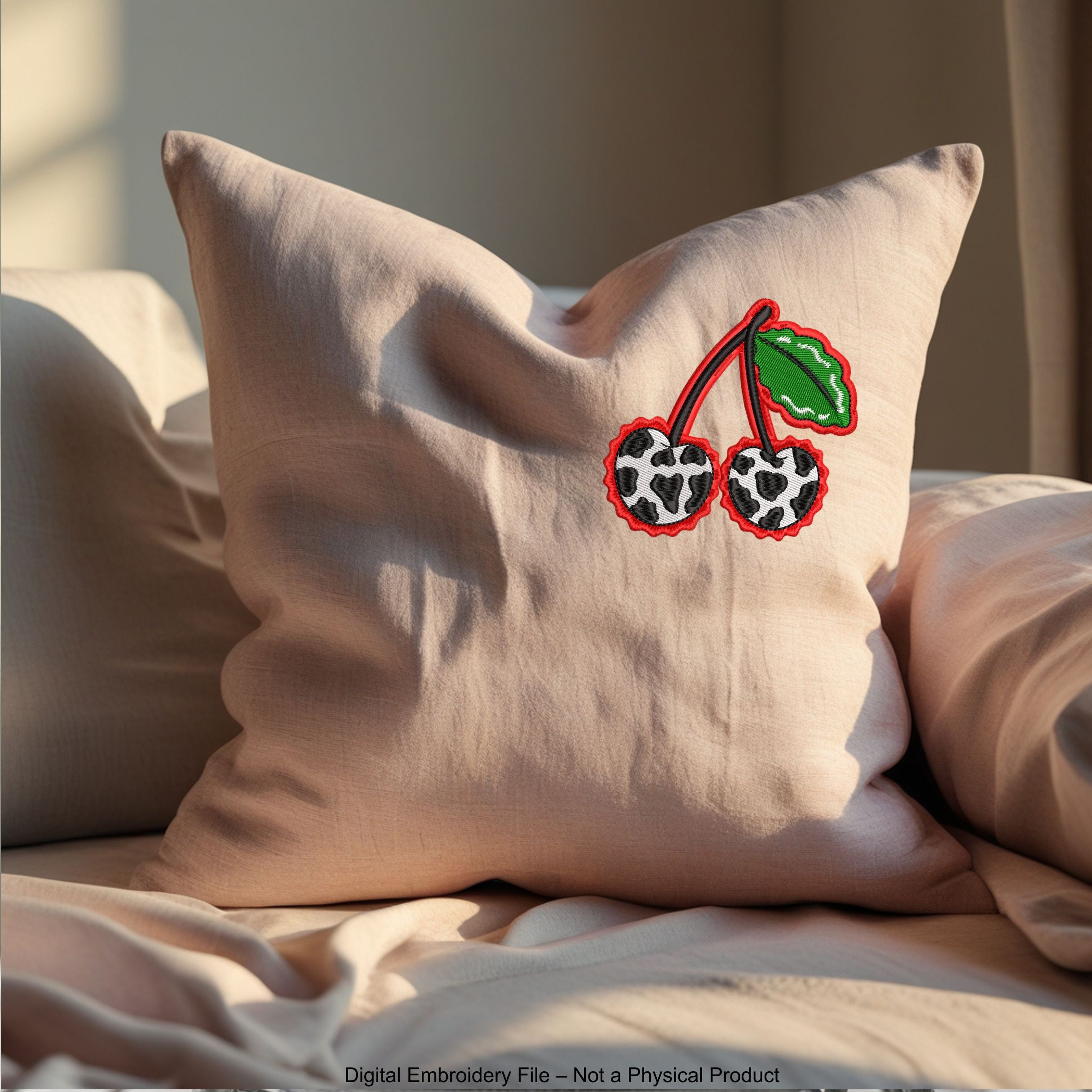 Two cherries with cow print texture and green leaves, finished with a wavy red border embroidery design.