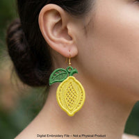 Three pairs of FSL lemon embroidery earrings — half-slice, whole lemon with green leaves, and round citrus slice — displayed on cream fabric, Free Standing Lace machine embroidery design.