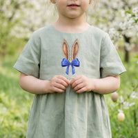 Machine embroidery design of bunny ears with blue bow, realistic fur texture, detailed embroidery stitches