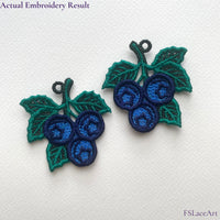 Actual Blueberry FSL embroidery held in hand with a second mirrored lace piece in the background