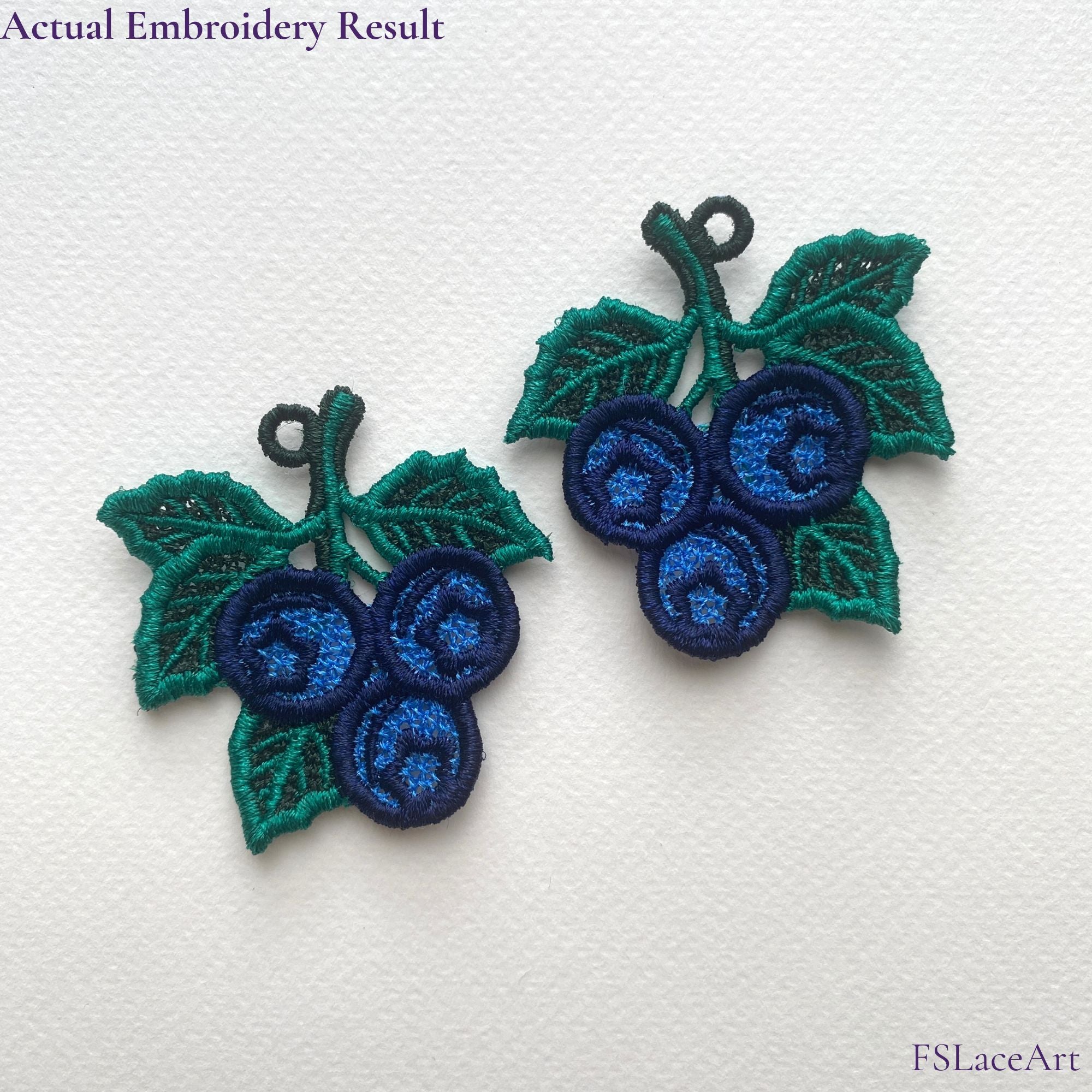 Actual Blueberry FSL embroidery held in hand with a second mirrored lace piece in the background