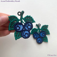 Two finished mirrored Blueberry FSL embroidery pieces with navy berries, green leaves and hanging loops