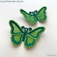 Two finished green FSL butterflies with lace-filled wings, contrasting satin borders and curled antennae