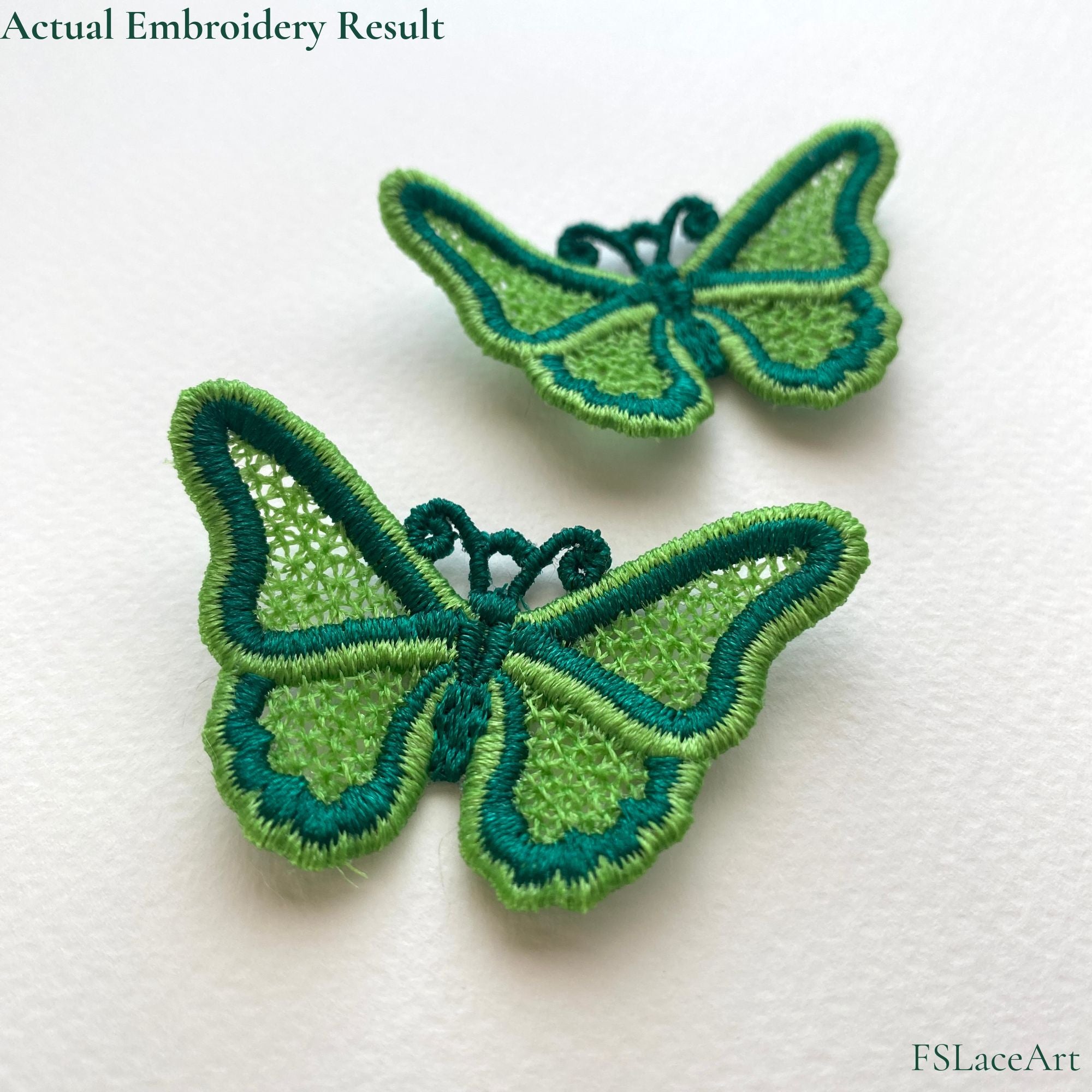 Two finished green FSL butterflies with lace-filled wings, contrasting satin borders and curled antennae