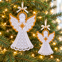 Two white and gold lace angel ornaments in different sizes hanging on a Christmas tree with ribbon bows and warm lights.