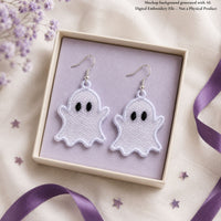 Pair of white Ghost FSL earrings with silver hooks displayed inside a lavender jewelry box