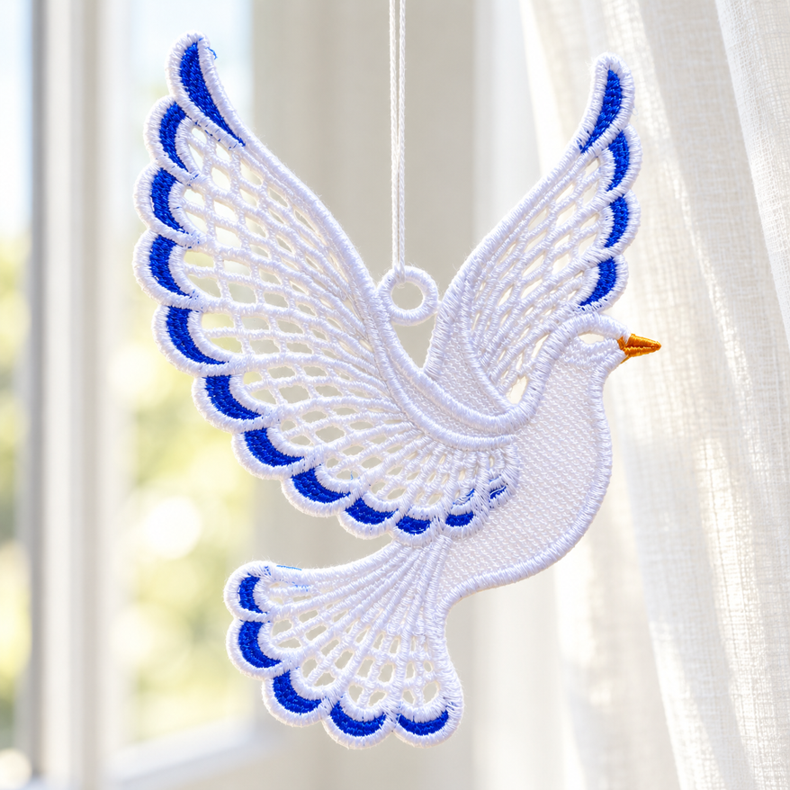 White freestanding lace dove with blue wing and tail accents, hanging beside a bright window and a sheer curtain.