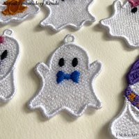 Actual white Ghost Boy FSL stitch-out with a blue bow tie displayed among other Halloween ghost designs