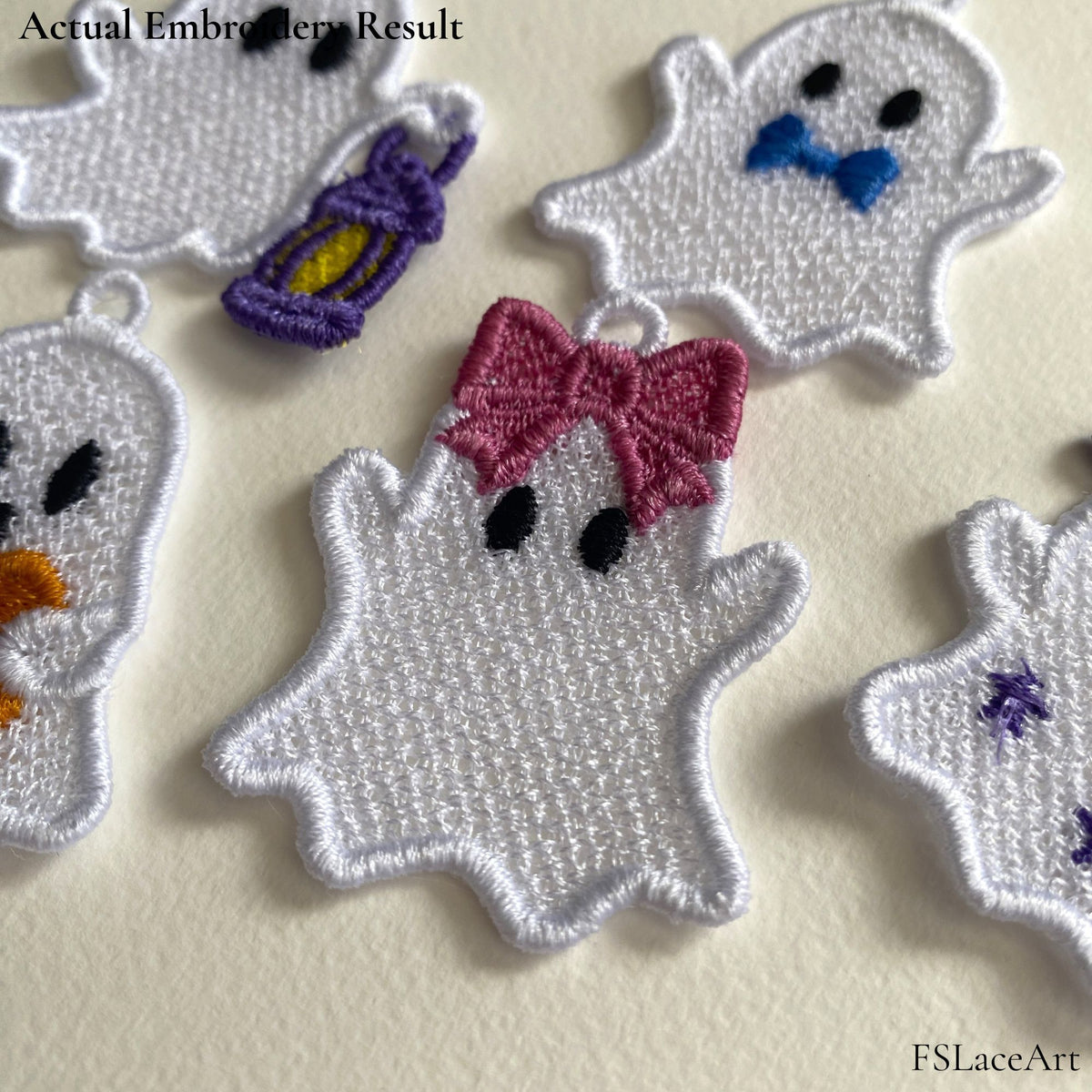 Actual white Ghost Girl FSL stitch-out with a pink bow displayed among other Halloween ghost embroidery designs