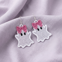 Pair of white Ghost Girl FSL earrings with large pink bows, black eyes and silver hooks on lavender fabric