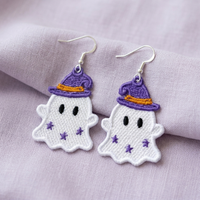 Pair of white ghost FSL earrings wearing purple witch hats with orange bands and purple star accents on lavender fabric