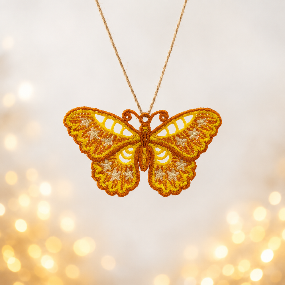 Golden floral butterfly FSL pendant with scalloped lace wings hanging from a natural cord