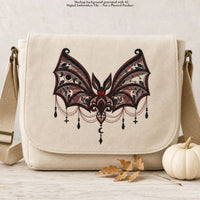 Cream shoulder bag mockup with ornate gothic bat embroidery in black, burgundy and red across the front flap.