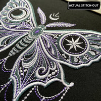 Actual gothic moon moth stitch-out on dark fabric in a hoop, with ornate wings and stitched chains ending in moons and stars.