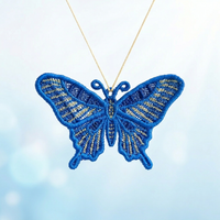 Large blue and gold swallowtail butterfly FSL pendant hanging from a golden cord against a soft background