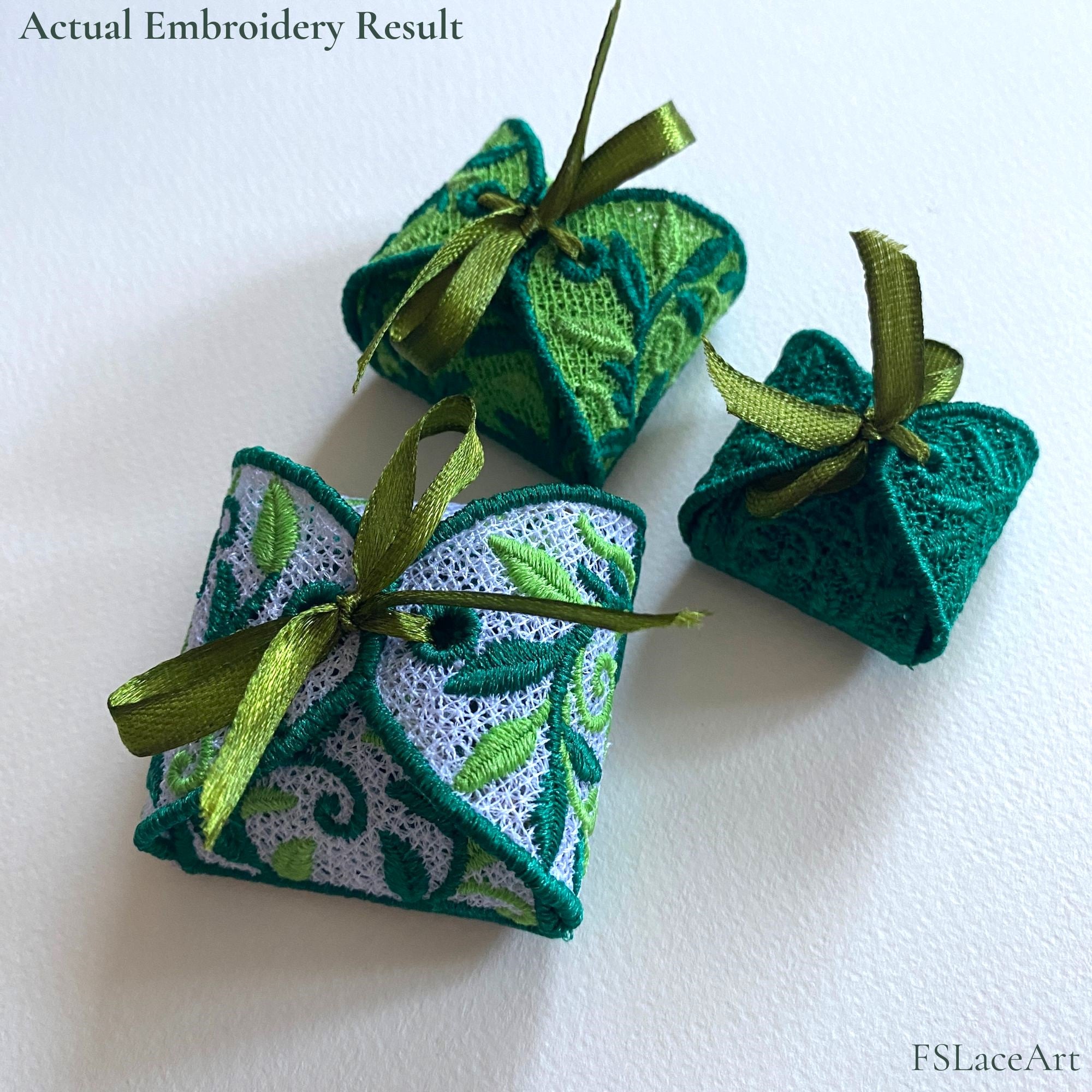 Three finished Leaf FSL gift boxes in white, light green and dark green thread with ribbon bows