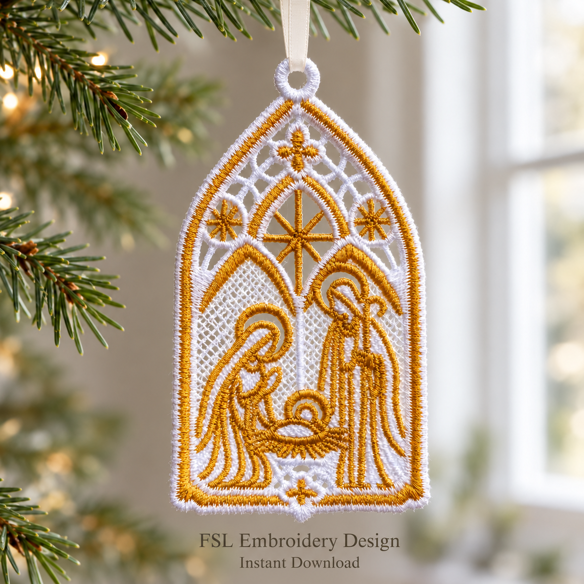 White and gold Holy Family lace ornament hanging from a satin ribbon beside Christmas tree branches and a bright window.