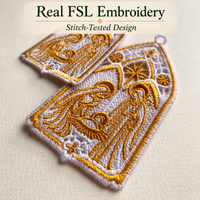 Close-up of finished nativity lace ornaments showing gold stitching, white openwork and the Holy Family inside a pointed arch.