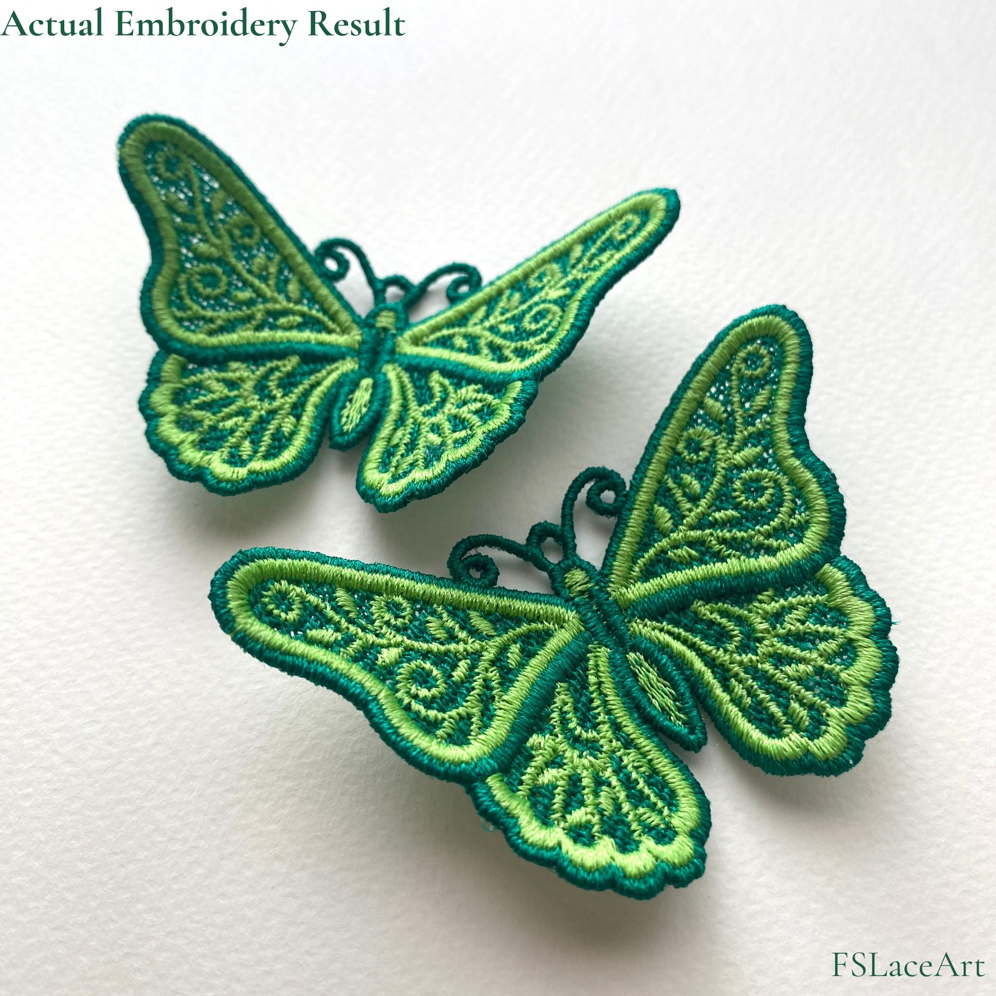 Two finished green FSL butterflies with raised wings, light green leafy scrollwork and dark green satin borders