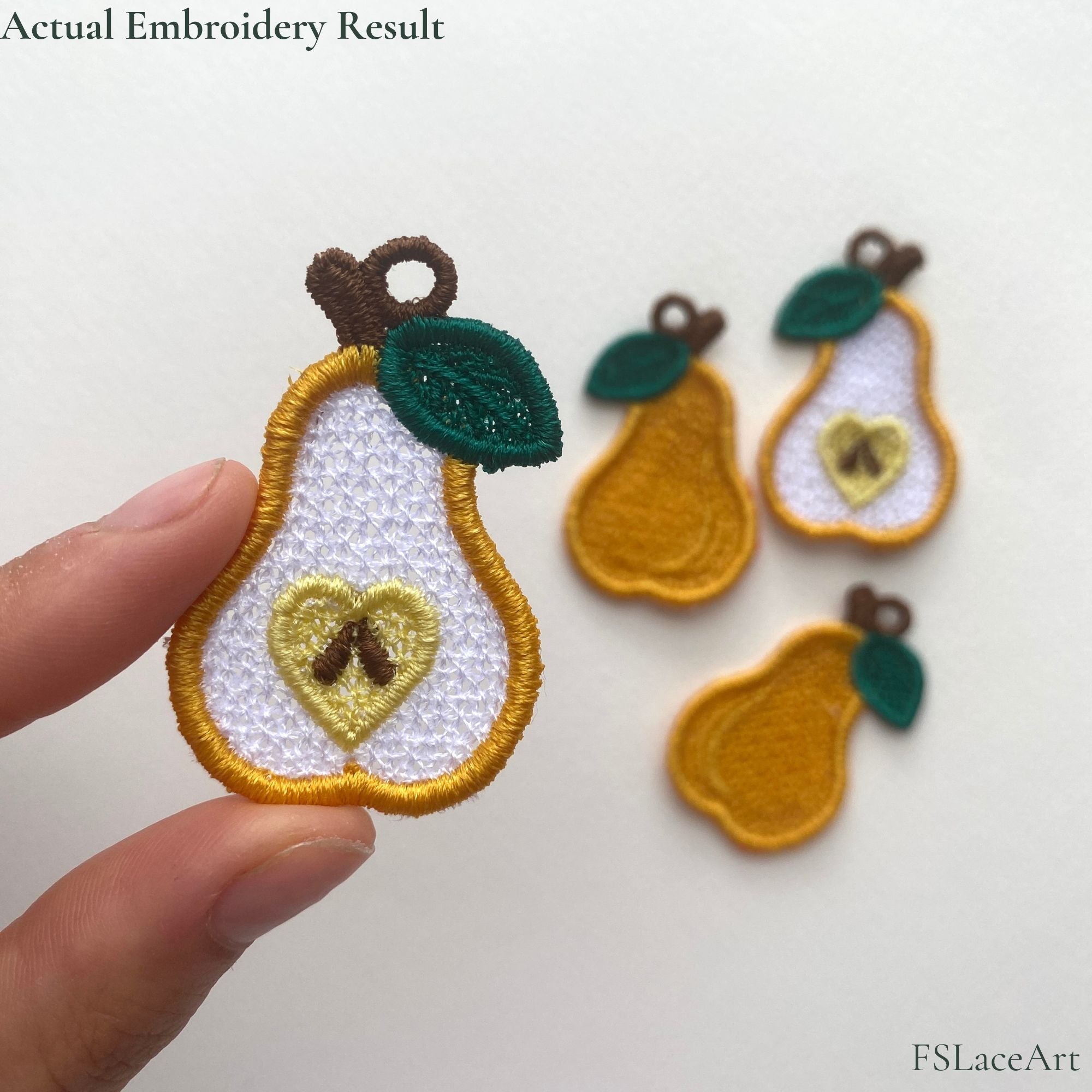 Actual sliced pear FSL embroidery held in hand with a heart-shaped core and brown seed details