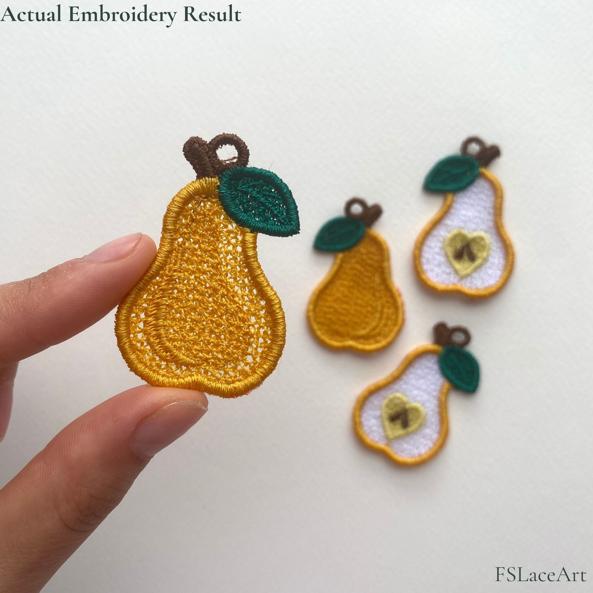 Actual whole pear FSL embroidery held in hand with finished whole and sliced pear designs in the background
