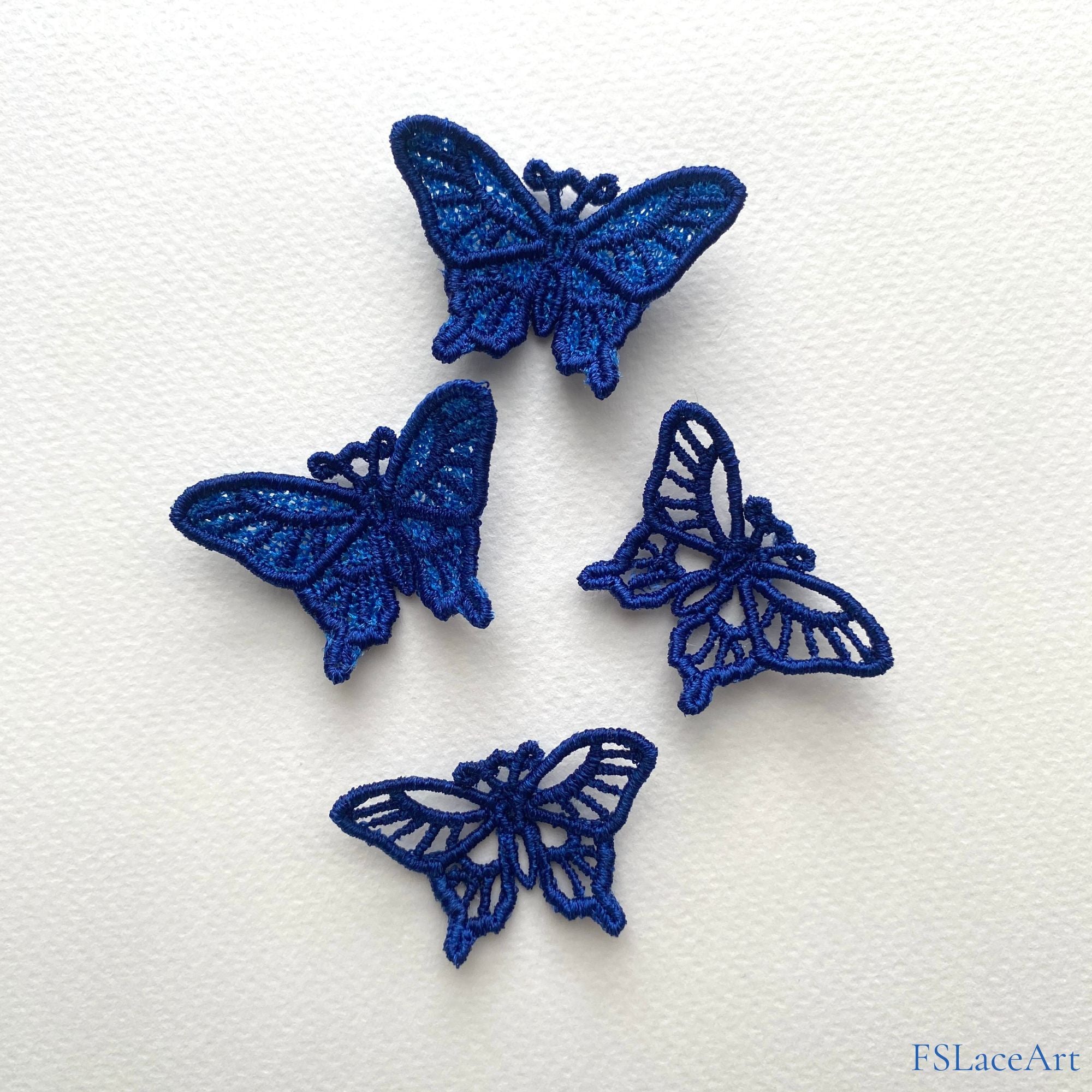Four finished blue swallowtail butterfly FSL stitch-outs with open cutwork and lace-filled wings