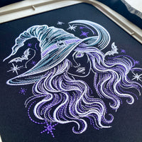 Witch portrait stitched on dark fabric in an embroidery hoop, surrounded by bats, stars and a crescent moon.